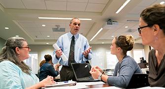 Photo of faculty helping adult students